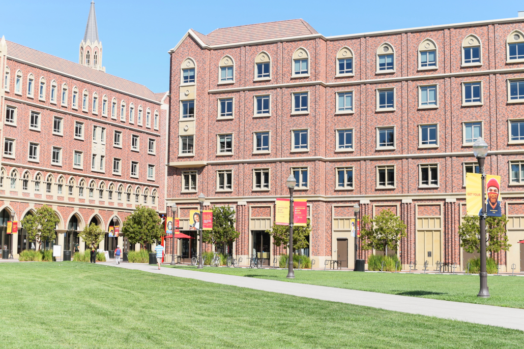 Photo of the University Village housing, with red-brick buildings and a green lawn.