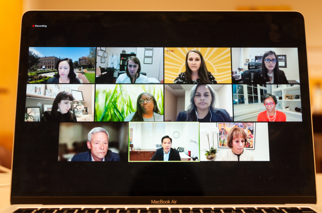 Photo of a Zoom webinar screen on a laptop with 11 members of USC administration in boxes.