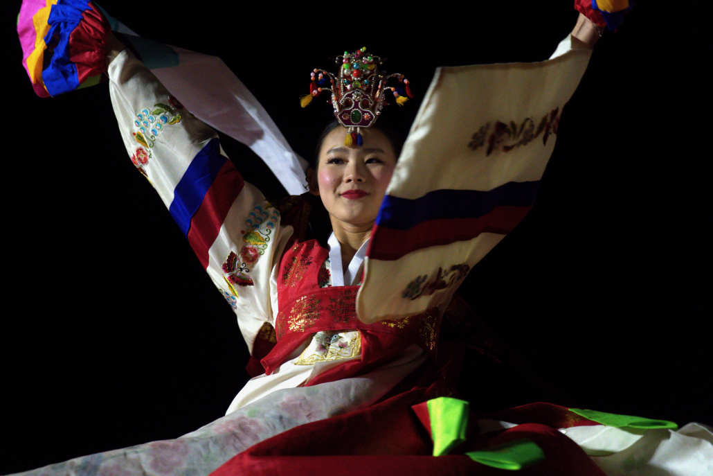 A female dancer performs while wearing traditional Korean hanbok.