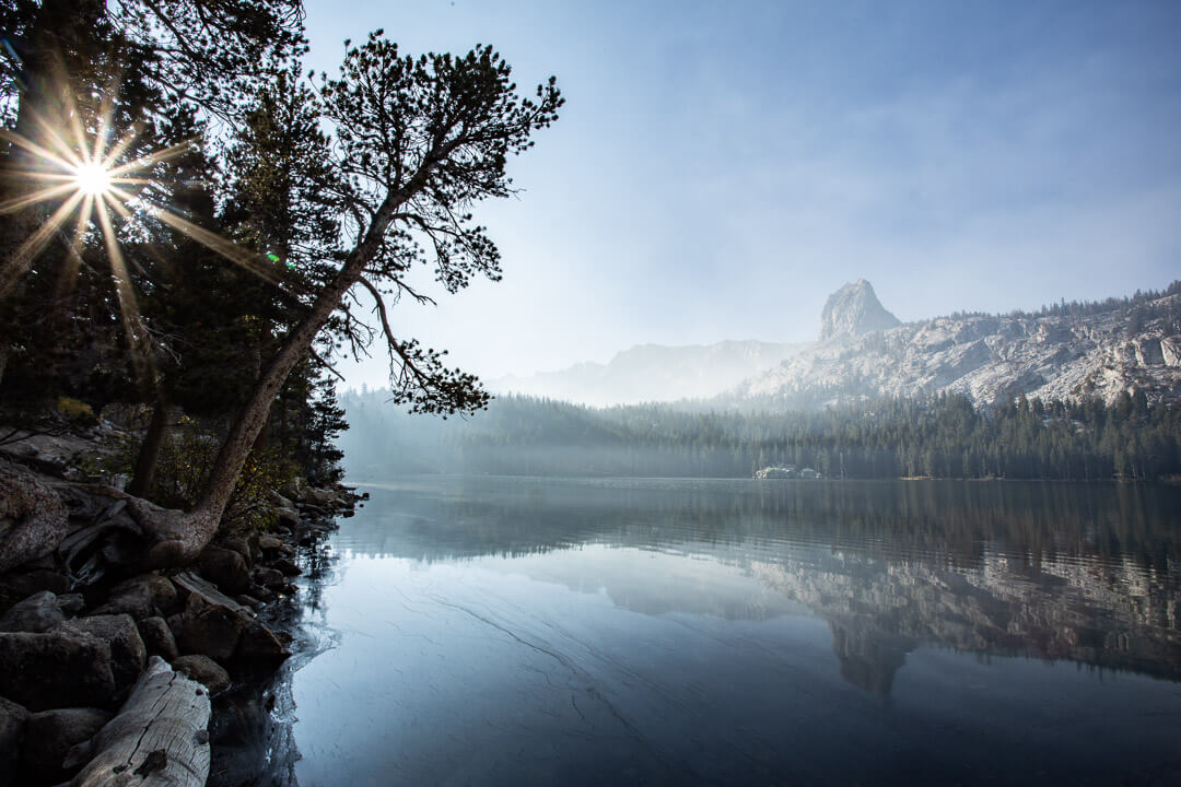 Lake under clear skies with rocks and trees behind