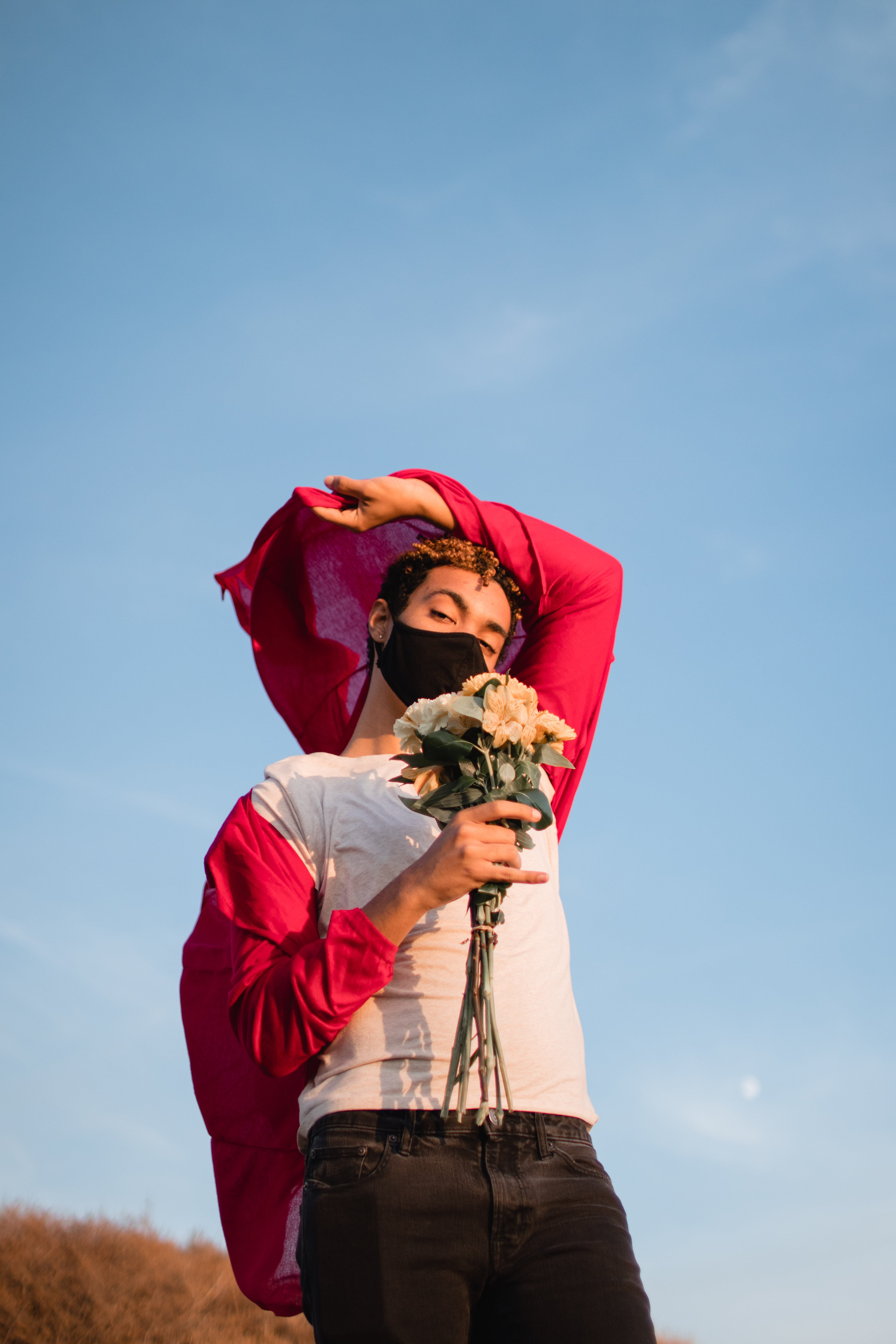 Person holding flowers in the wind