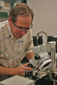 Research · Mark Thompson, co-director of the federally funded Energy Frontier Research Center, looks at samples with a microscope. | Dieuwertje Kast 