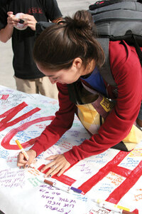 Trojan family · Kathleen Fletes, a senior majoring in psychology, writes a message on a banner for injured running back Stafon Johnson in front of Tommy Trojan Tuesday. - Mike Lee | Daily Trojan