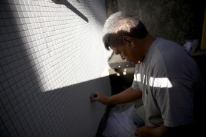 Home of the Future · A contractor spreads grout over tiles in the fluxHome. The house showcases eco-friendly building techniques. - Ralf Cheung | Daily Trojan 