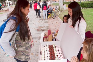 Giving back · Tiffany Chu, a junior majoring in gerontology, receives a cupcake from Cindy Le, the lead coordinator of “Clothes for Cupcakes,” for donating a t-shirt on Trousdale Parkway on Thursday. - Austin Vogel | Daily Trojan 