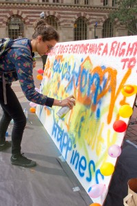 Tagging · Sophia Nagar, a freshman majoring in theatre, spray paints “laughter” near Tommy Trojan as part of World Day of Social Justice. - Austin Vogel | Daily Trojan 