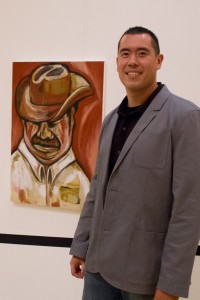 Hidden talent · Sergeant Rick Gonzales poses next to his painting, “The Mexican,” at the art exhibit “Beyond the Badge” in the Galen Center. - Austin Vogel | Daily Trojan 