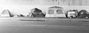 Tent city · Every night, thousands of people set up tents on the sidewalk to seek temporary shelter from the elements, such as below this freeway overpass on 39th Street. Government programs attempting to address homelessness have channeled resources into supporting single-room occupancy housing, which has left many women and children without homes. Hawken Miller | Daily Trojan