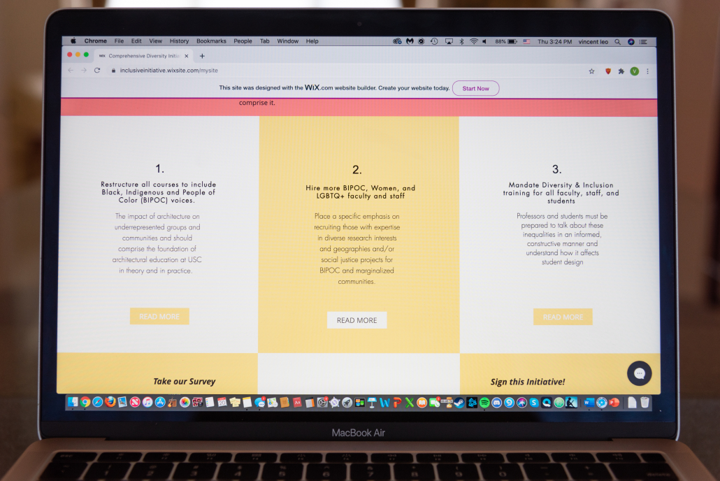 A Macbook Air displays three of six blocks included on the Comprehensive Diversity Initiative site of their six demands. The demands are displayed in a blocked pattern of white and yellow. 