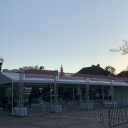 Photo of an entrance to USC campus with gates, white tents, and red banners that read “campus day pass only.”