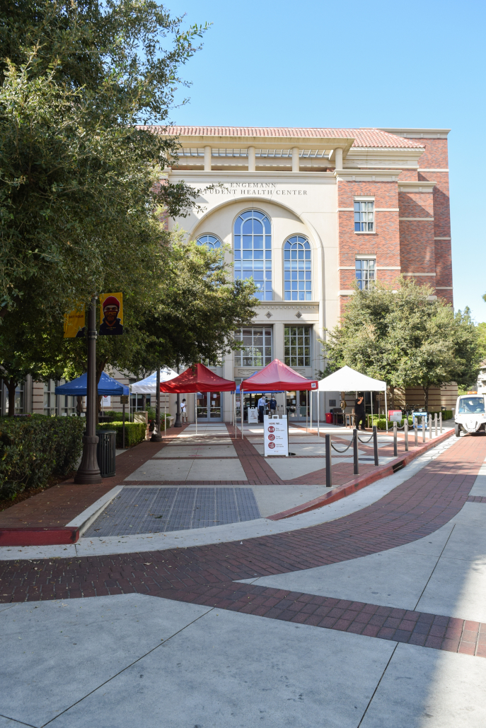 Photo of Engemann Student Health Center with tents of varying colors in front of the entrance. 