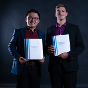 Photo of Brian Femminella and Travis Chen holding binders that read “SoundMind Solutions.”