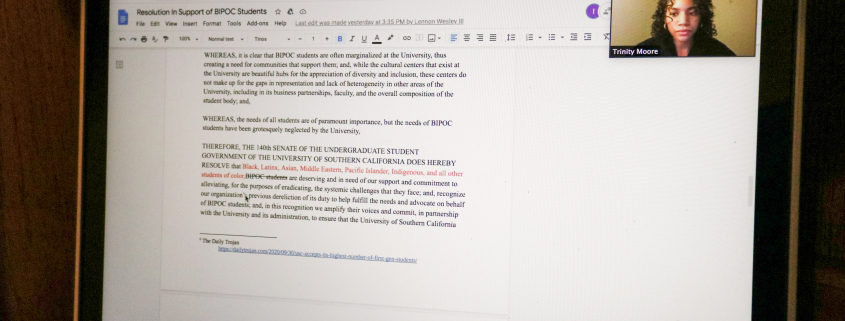 Photo of a Mac laptop screen showing a document, with the right displaying the title “Resolution in Support of BIPOC students.” A small window showing Undergraduate Student Government Vice President Trinity Moore is to the right.