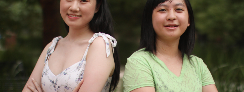 Jade Lee standing to the left with Jaclyn Dong to the right and both their arms folded