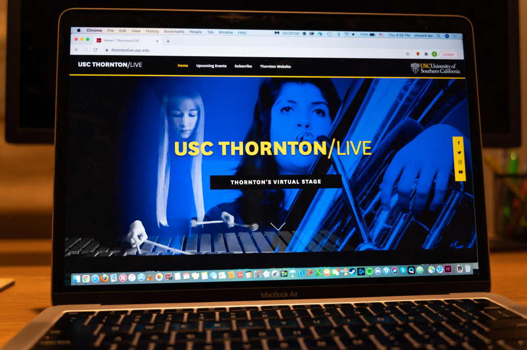 A laptop with the website of Thornton/LIVE pulled up. It features a woman playing a xylophone and another person playing a tuba.