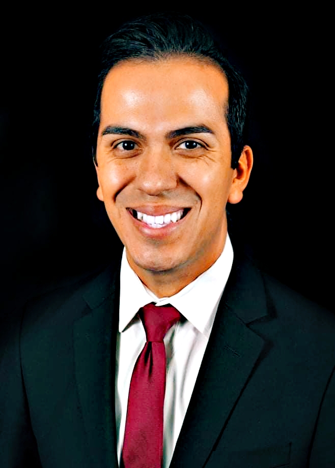 A picture shows  a headshot of James Martinez smiling in a suit with a red tie.
