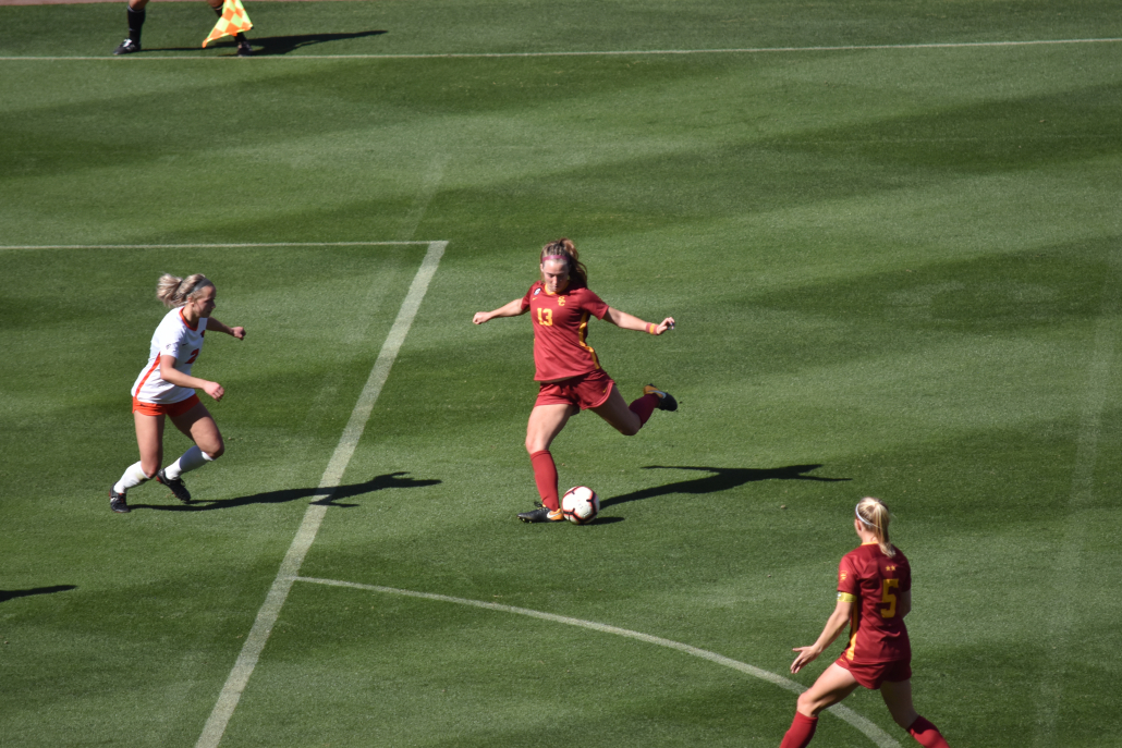 Senior forward Tara McKeown kicking outside of the box as a defender approaches.