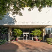 The front entrance to the old Annenberg building, which is where the CPD is located. It is a white building with brick pavement in front of it. A tree branch hangs over the front.