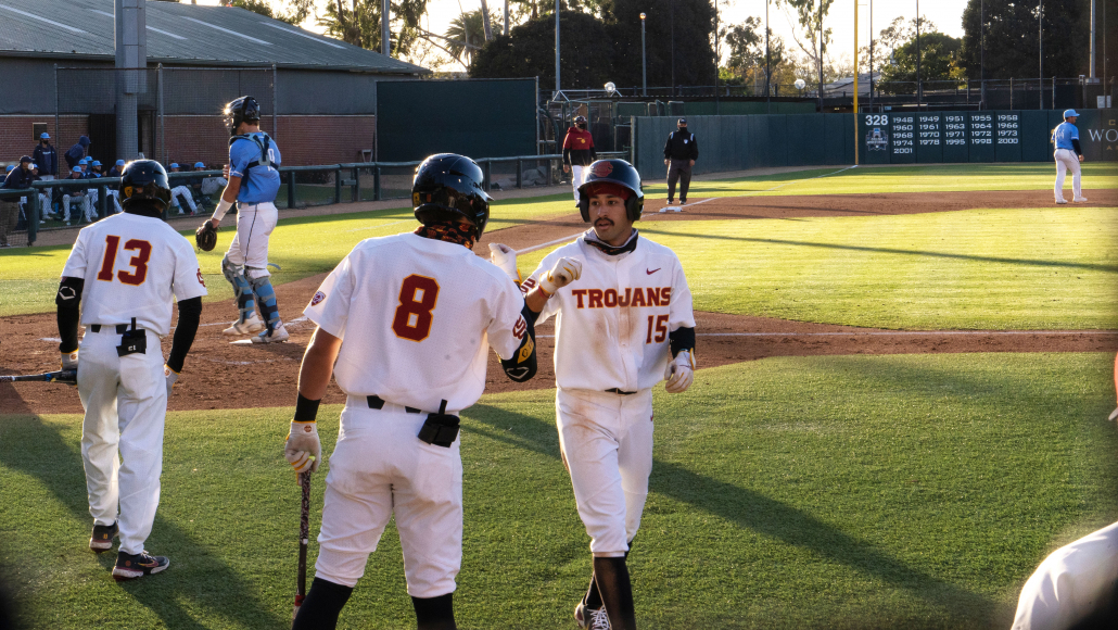 Number 15 redshirt freshman Rhylan Thomas dabs up number 8 redshirt junior Ben Ramirez on his way to the dugout 