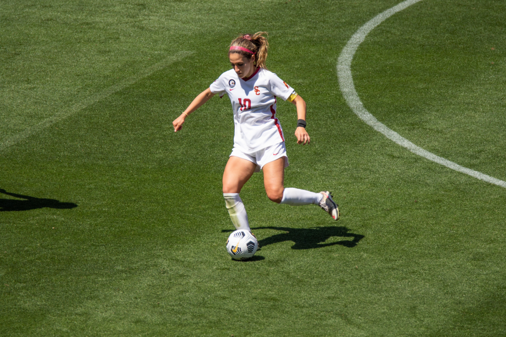 Redshirt senior Savannah DeMelo, No. 10, is pictured dribbling a soccer ball in the midfield, faced towards the ball.