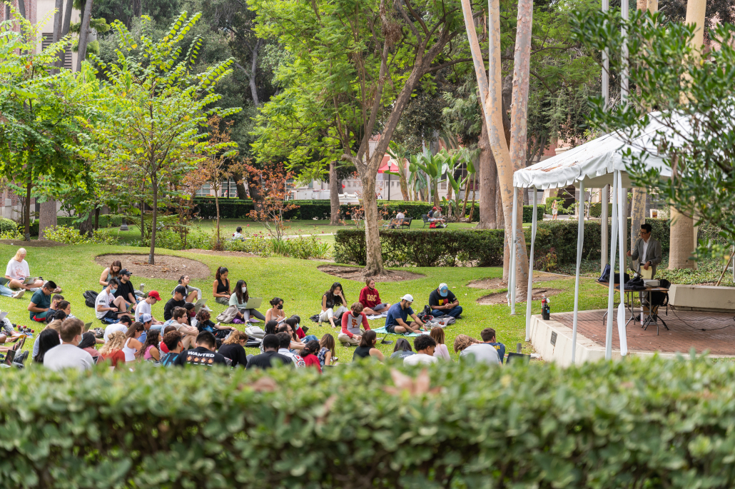 Students sit on the grassy lawn outside the Annenberg School of Communication and Journalism listening to their professor lecture.