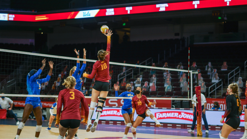 In a game against UCLA March 19, sophomore middle blocker Aleksandra Gryka, number 18, reaches for a ball in the air over the net, looking to spike it between multiple UCLA defenders. 