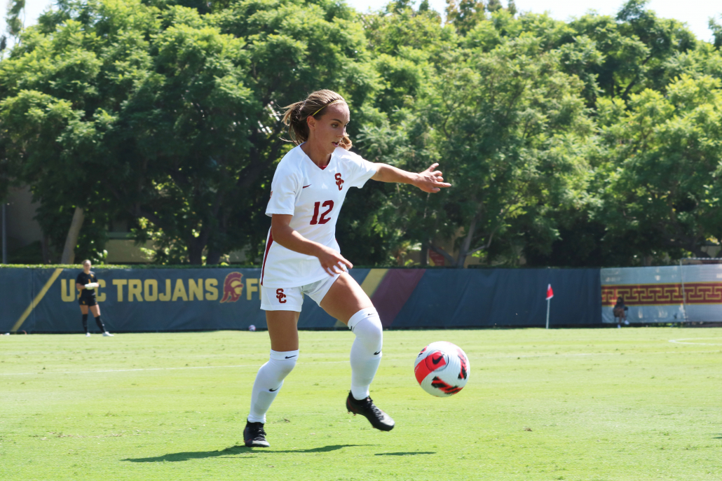 Sophomore defender Zoe Burns dribbles the ball in the middle of the field.