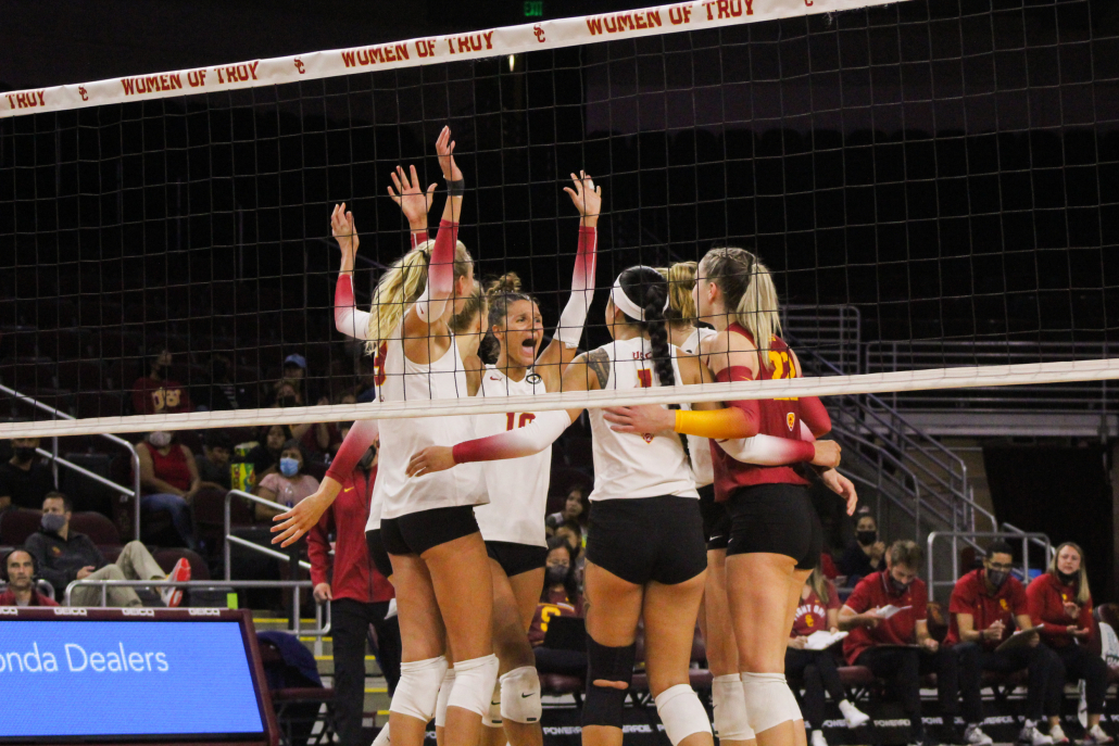 The USC women's volleyball team hugs each other after a point.