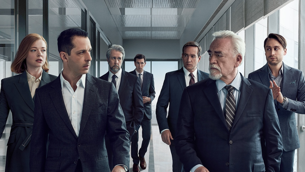 Image of several people looking at each other in suits. 