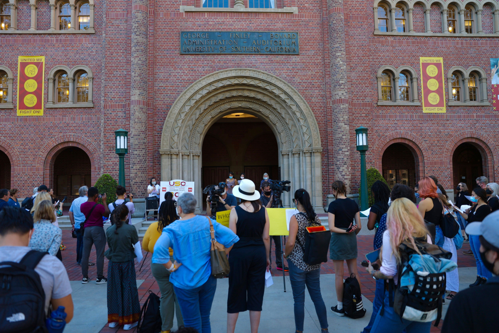 Protestors stand in front of Bovard Auditorium. 