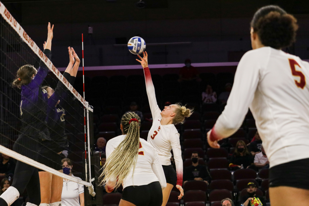 Junior opposite hitter Emilia Weske reaches up to hit the ball over Washington players.