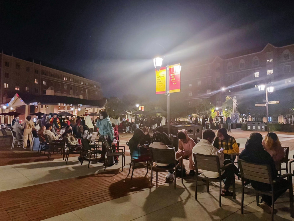 Photo of students in USC village on chairs waiting in a long line for Insomnia Cookies.