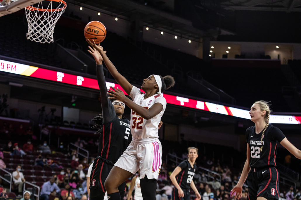 USC player in white goes for a layup against Stanford players in black