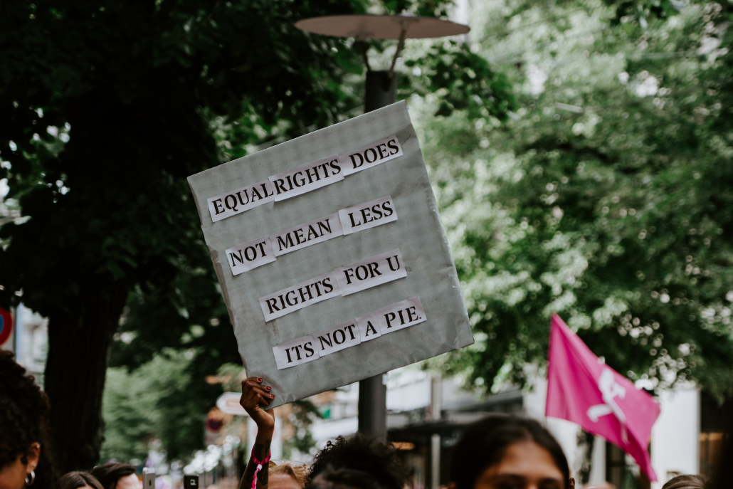 Stock photo of a protester holding up a sign that says, "Equal rights does not mean less rights for u its not a pie."