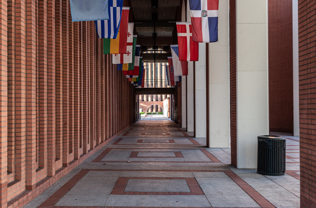 Photo of the Center for Public Affairs outdoor hallway with 11 flags from different countries hanging from the ceiling. 