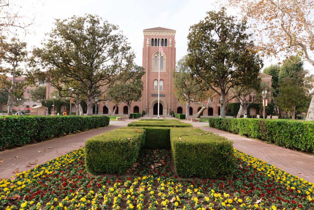 Front of Bovard Auditorium and flowers in Alumni Park. 