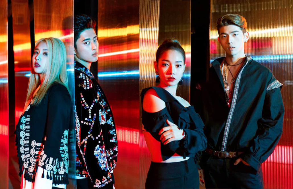 The four members of KARD posing against a psychedelic background, staring at the camera.