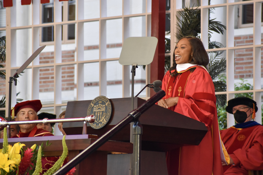 Allyson Felix speaking at commencement behind podium.