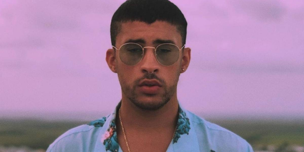 Photo of bad bunny posing infant of purple sky.