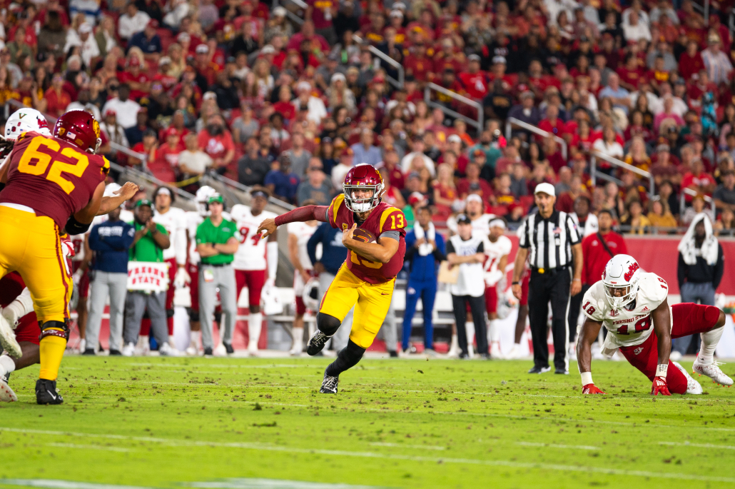 Quarterback Caleb Williams runs through traffic. 