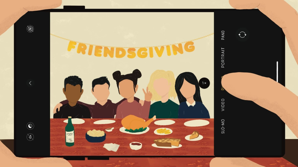 A person taking a photo of 5 friends at friendsgiving