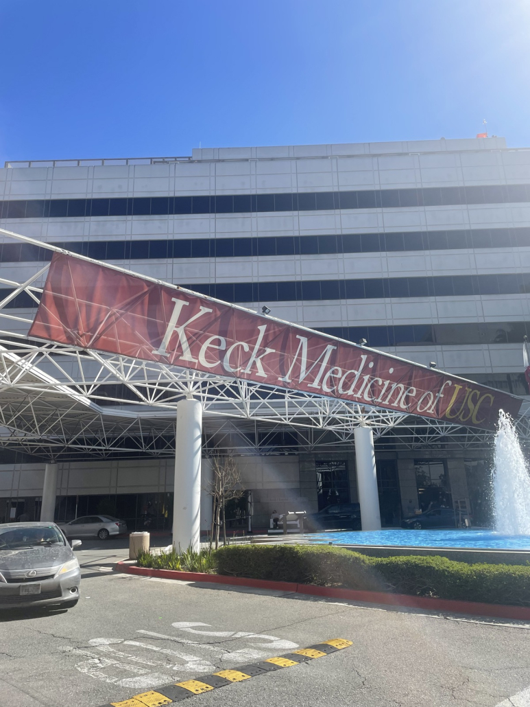 Photo of Keck Medicine of USC in the daylight. A grey car is in the frame.