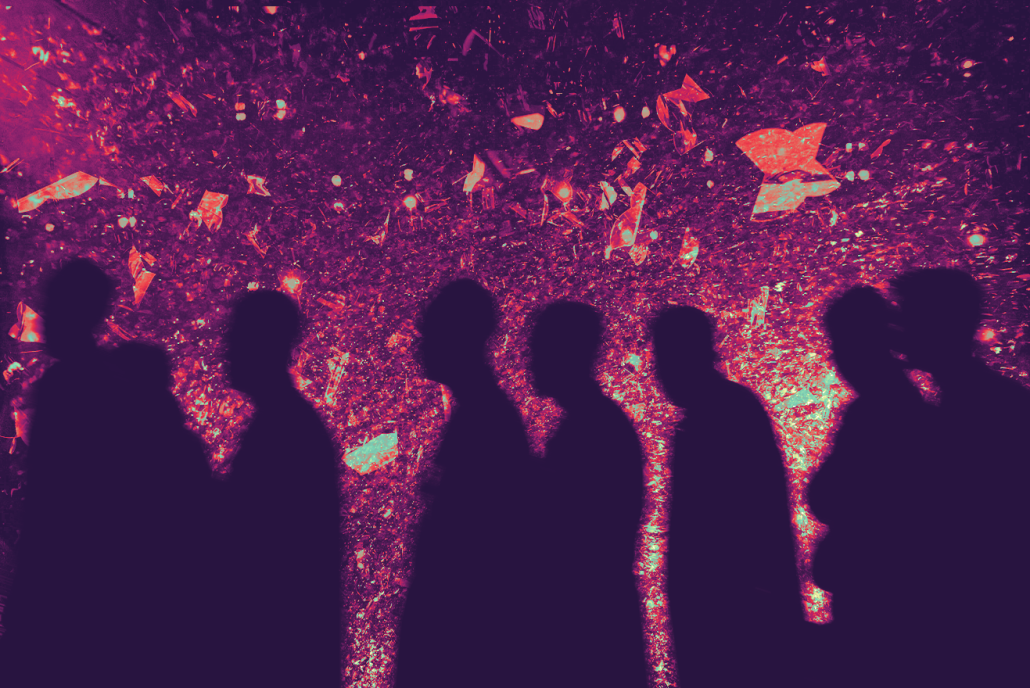 Silhouttes of people in a line against a colorful background.