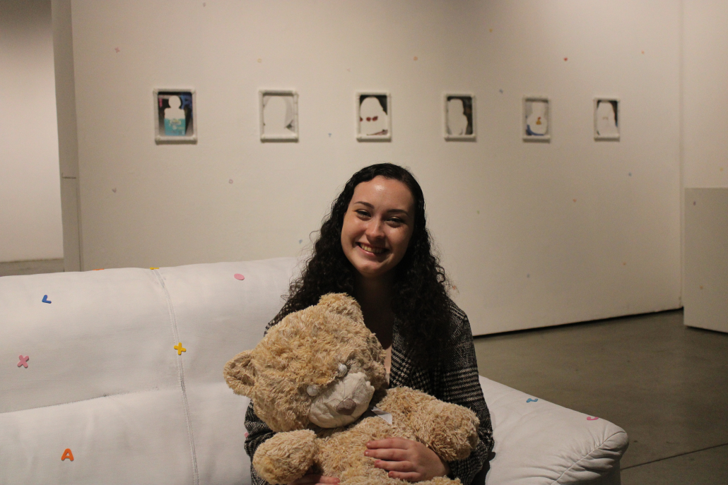 Girl smiling holding teddy bear.