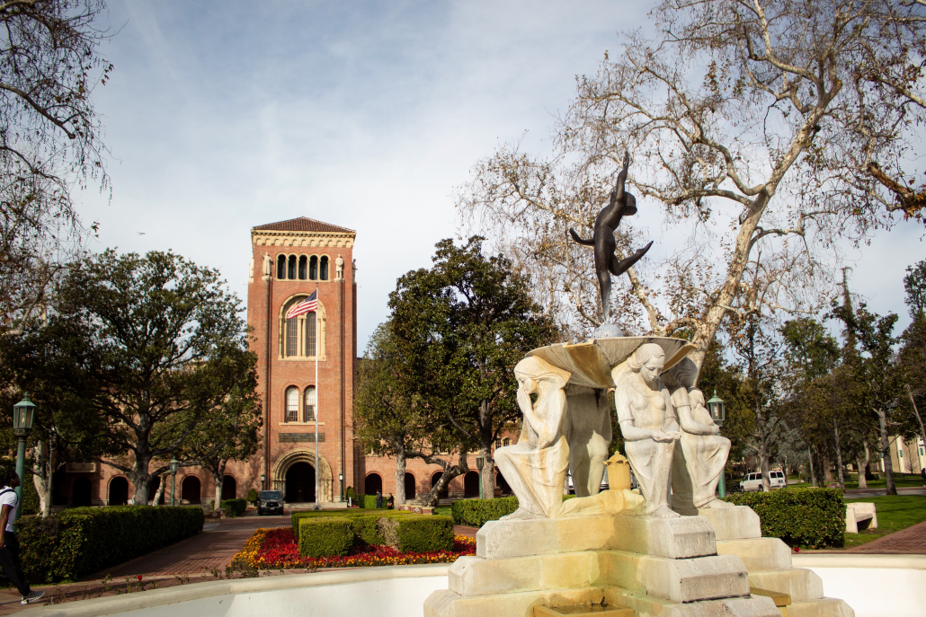 Campus photo shows the fountain in front of Doheny Memorial Library with Bovard Auditorium in the background.