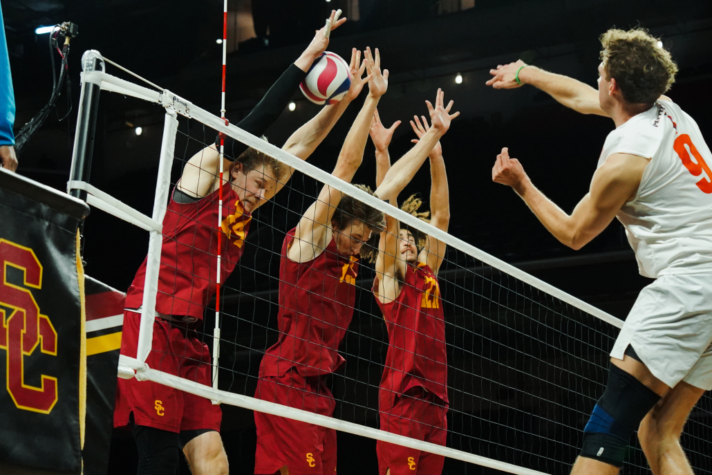 USC Volleyball players jumping to block a shot.