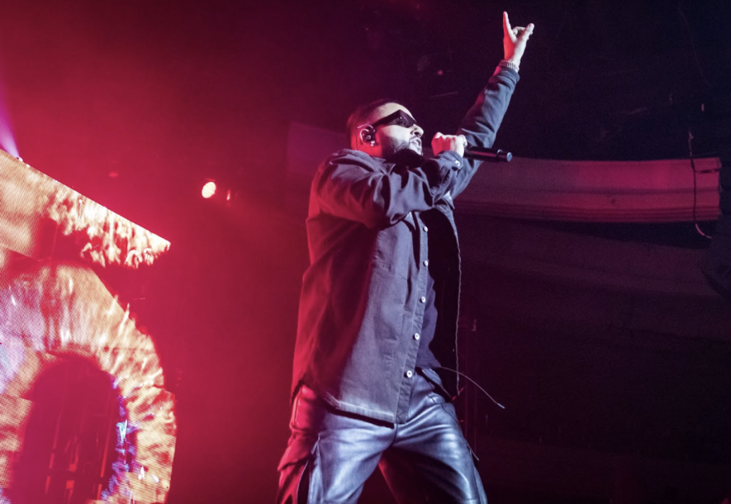 NAV performs on stage with red lighting.