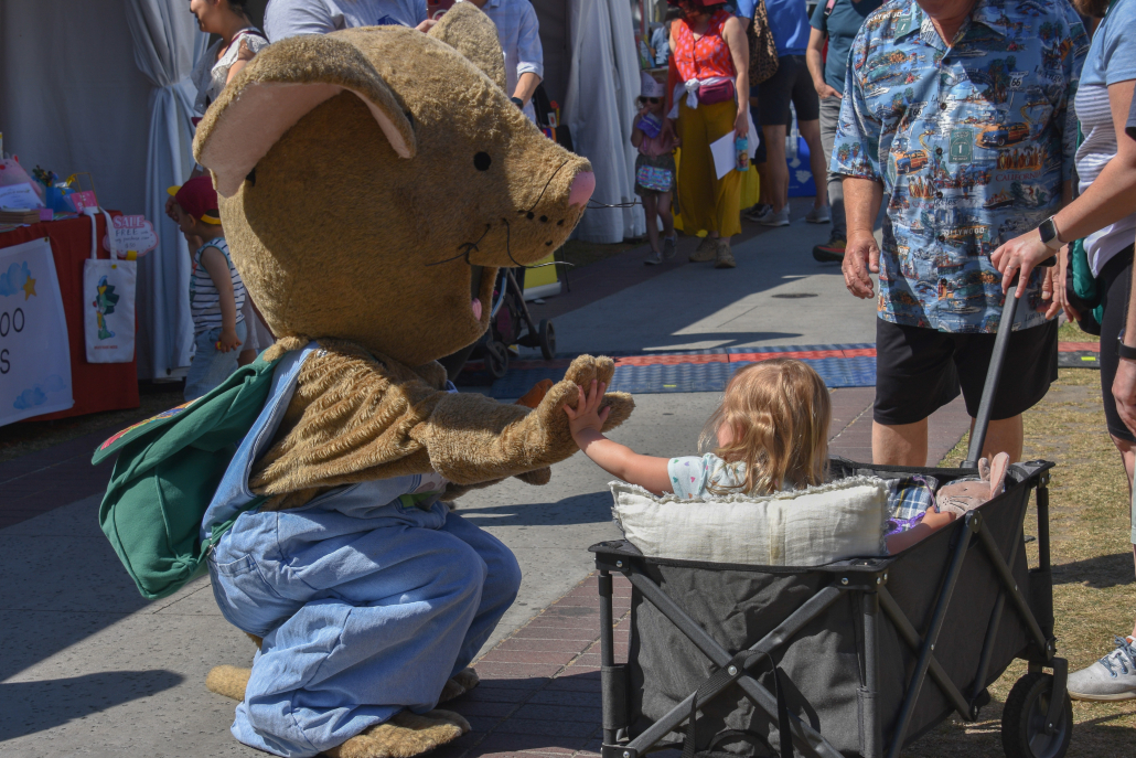 A mouse mascot high fives a baby