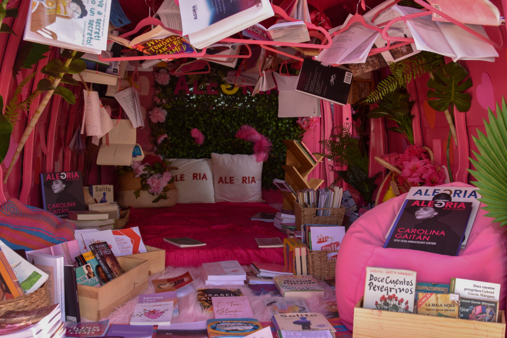 A pink tent is filled with books and plants