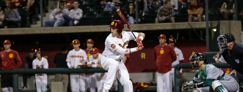 a baseball player holding a bat on top of a field.